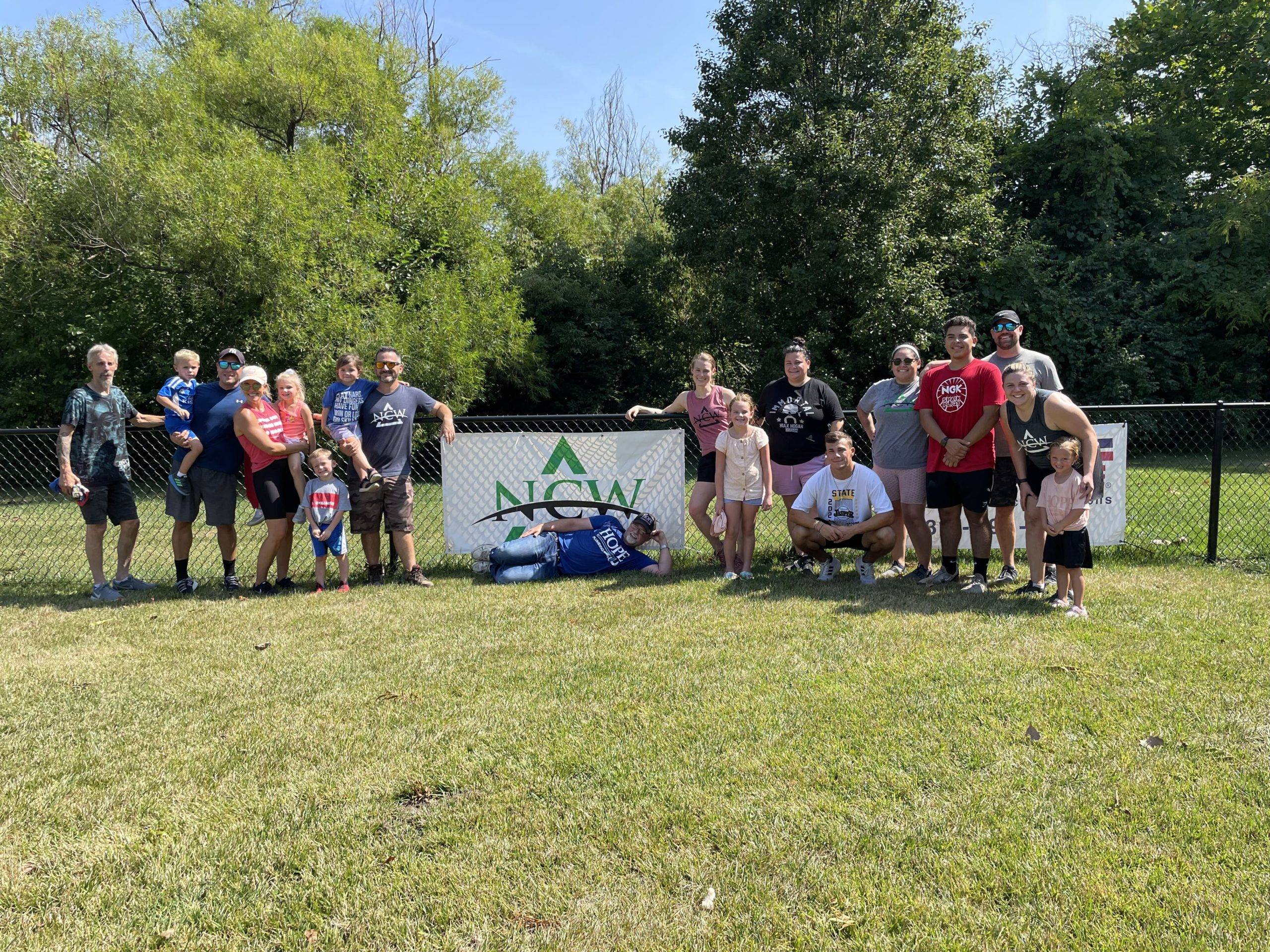 Team NCW and Hope Plumbing pose with NCW banner on Skiles Test field 