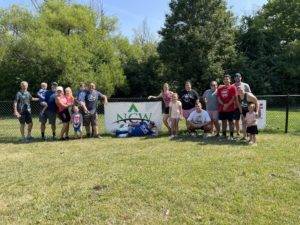 Team NCW and Hope Plumbing pose with NCW banner on Skiles Test field