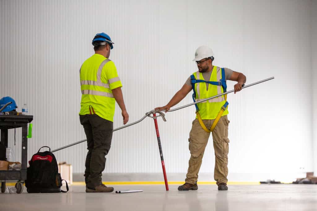 pipefitters measuring a pipe